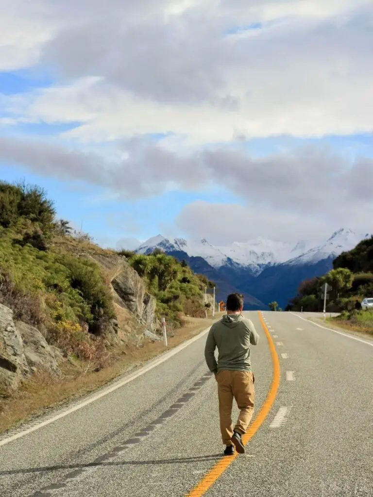 Un nomade en voyage sur la route devant les montagnes en Nouvelle-Zélande