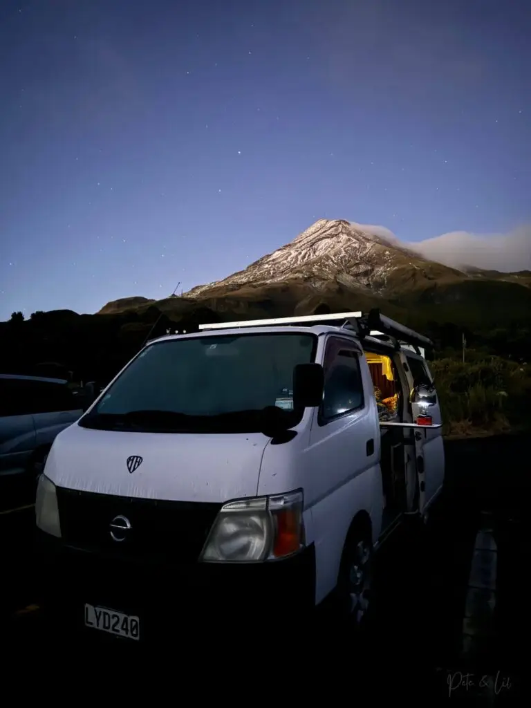 Un van au pied du mont Taranaki au lever du soleil en Nouvelle-Zélande