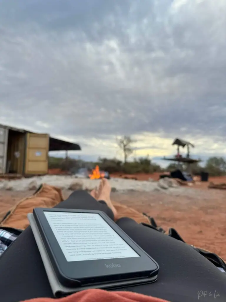 Moment de lecture paisible devant un feu de camp en voyage dans le désert australien