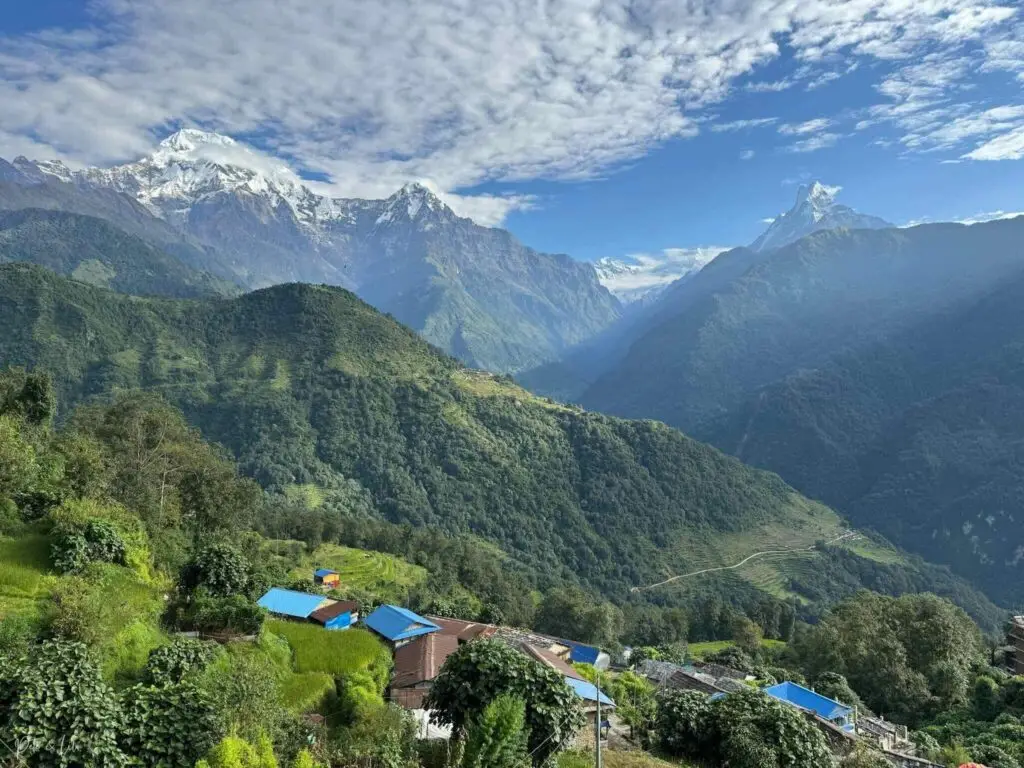 Village népalais avec toits bleus et sommets enneigés des Annapurnas