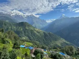 Village népalais avec toits bleus et sommets enneigés des Annapurnas