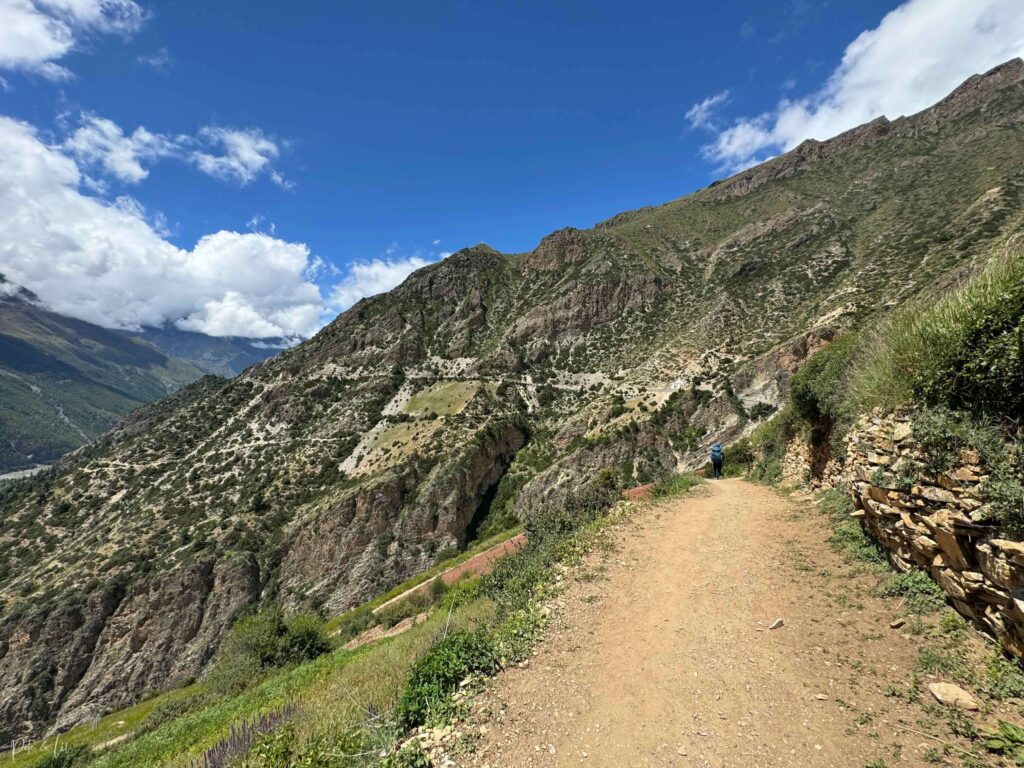 Randonneur sur sentier avec des sentiers au loin dans les montagnes