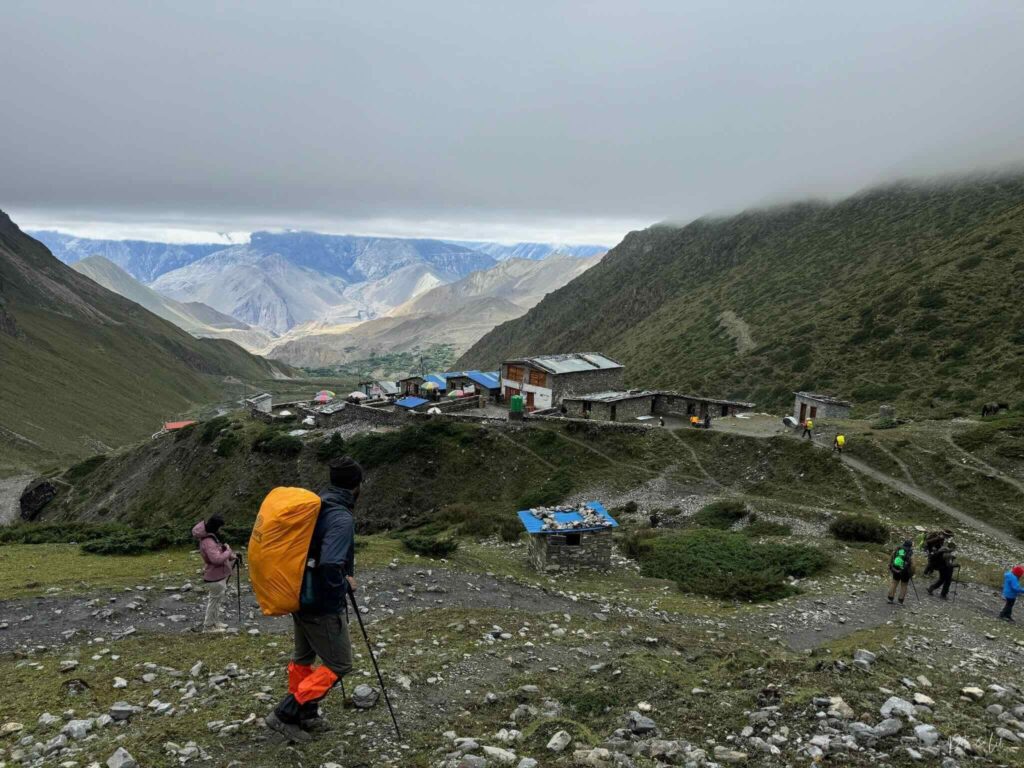 Banc de nuages au-dessus d’un village avec randonneurs