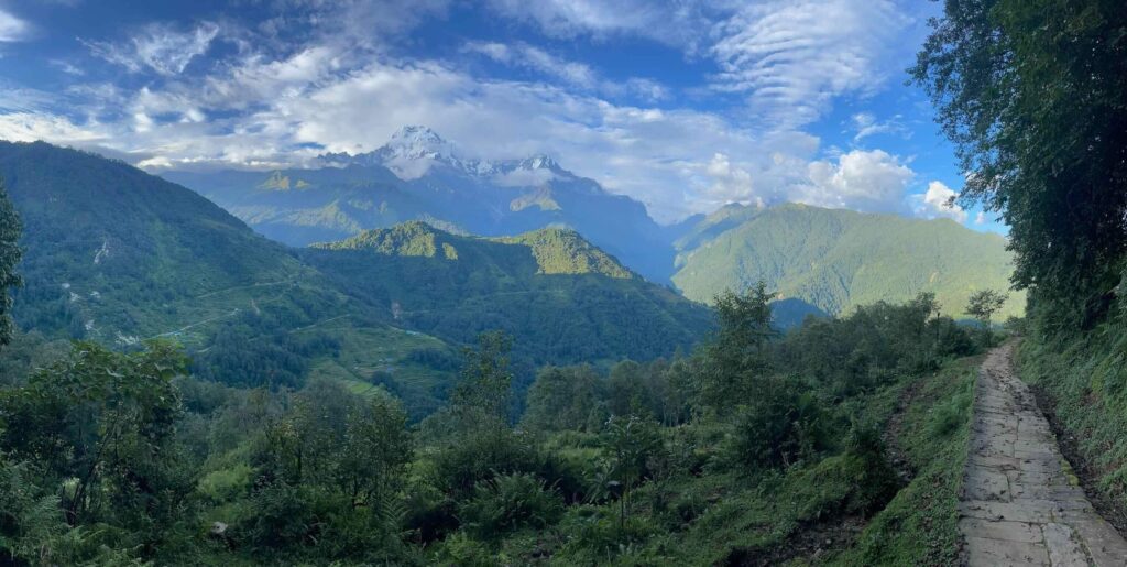 Sentier longeant une falaise avec montagnes en arrière-plan